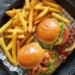 2 turkey burgers using Gordon Ramsay method with potatoes on a plate.