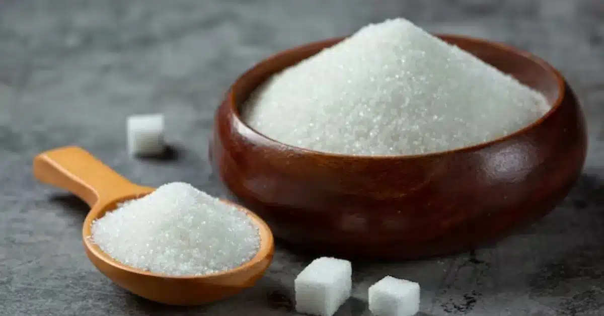 sugar: one of the five elements are crucial in cake-making in wooden bowl on dark surface