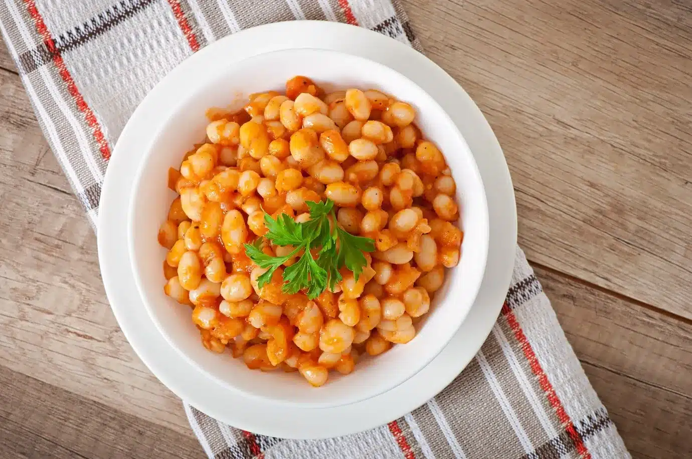 Bowl of baked beans on a wooden table