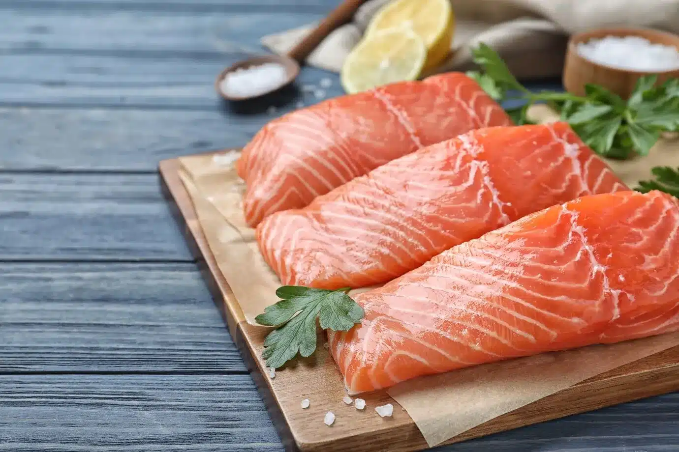 fresh raw salmon with parsley on blue wooden table fish delicacy ready for baking at 350°F