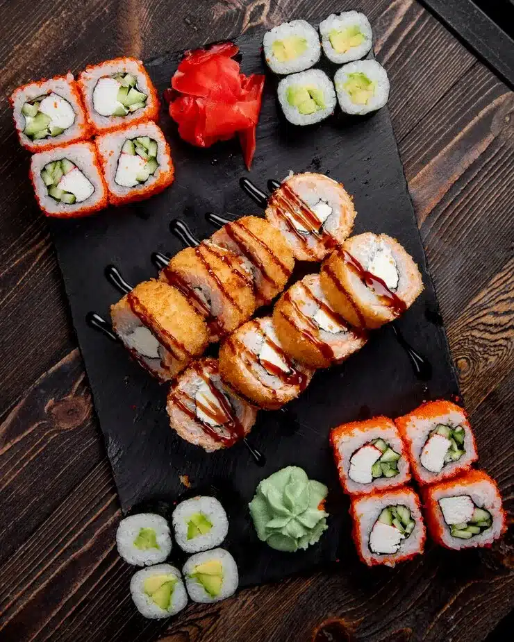 Sushi platter with a variety of sushi rolls, nigiri, and sashimi, served with soy sauce, wasabi, and pickled ginger.