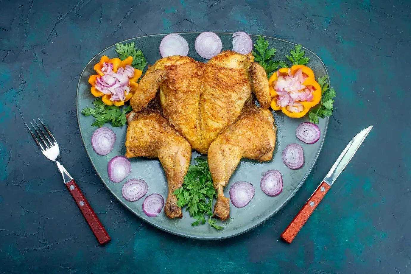 whole fried chicken on a plate and onions